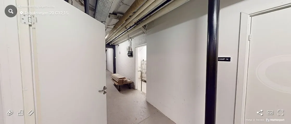 Lagerrum med to hvide døre, hvoraf den ene er åben og den anden har etiketten "Camp 14". Indersiden er hvid og ren, og der