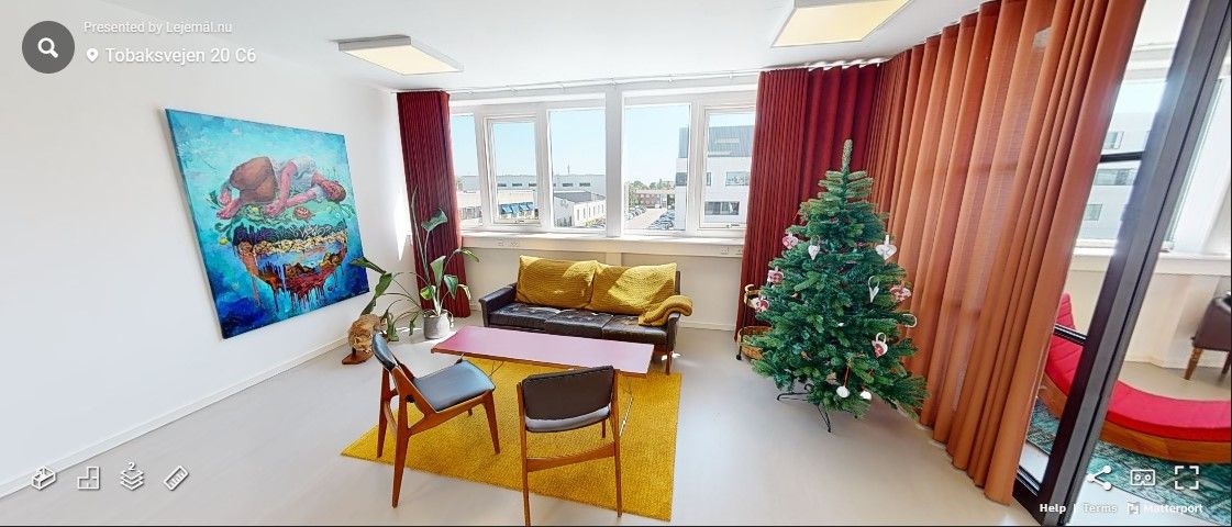 Foto af en rummelig lejlighed med lysegul gulvved, juletræ og lysegul sofa med lysegule puder