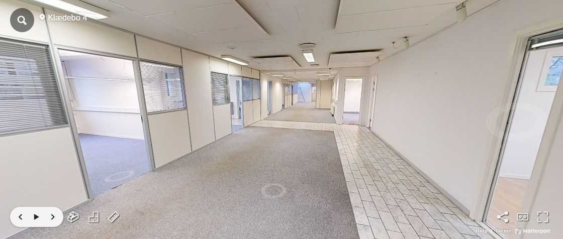 Hørsholm kontorlokaler med moderne indretning og lyse gulve, slanke glasvinduer og hvide vægge. Foto med Matterport.