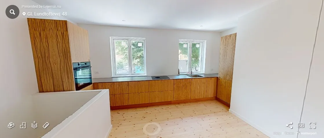 Lejlighed med nyrenoveret køkken med lyse træskabe og moderne apparater, to vinduer og en høj garderobe