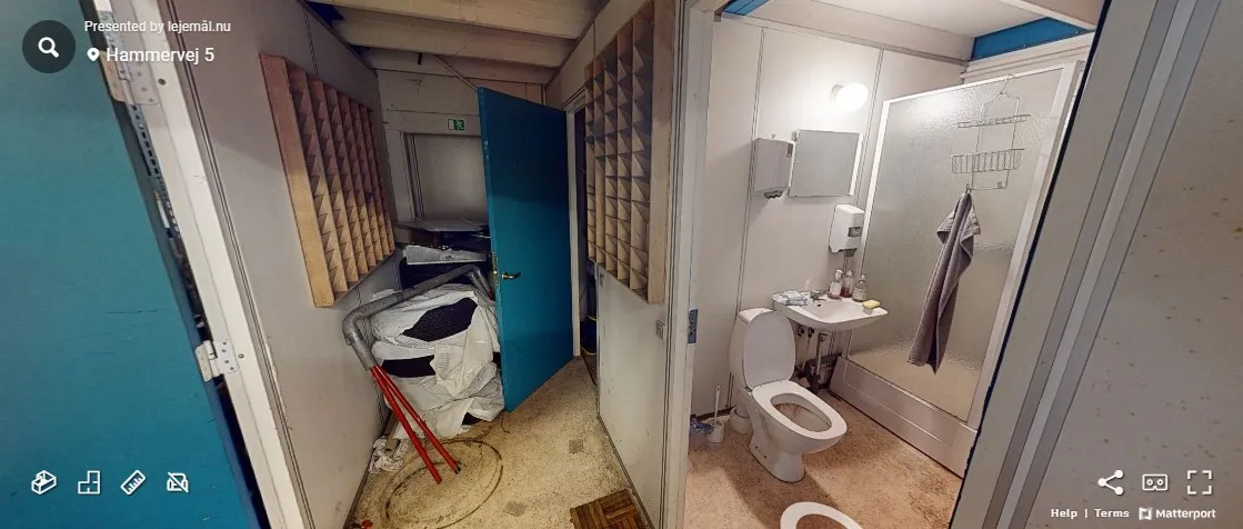 Badstuen er tom med toilet og vask og lysekroner på loftet. Der er stående tøj i toilettet.