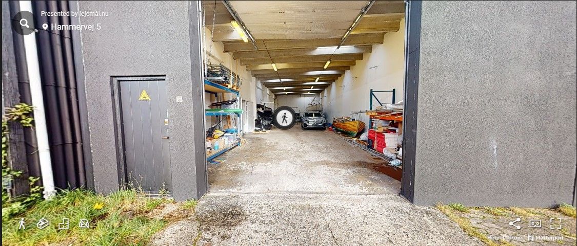 Hammervej 5 er en lagerbygning med 870 højloftet m². Der er et alu port og et parkerede køretøj inde i lagerbygningen.