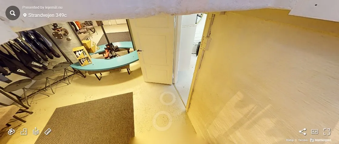 Inde i et lager med en gul bord og flere stole samt nogle objekter i en hjørne.