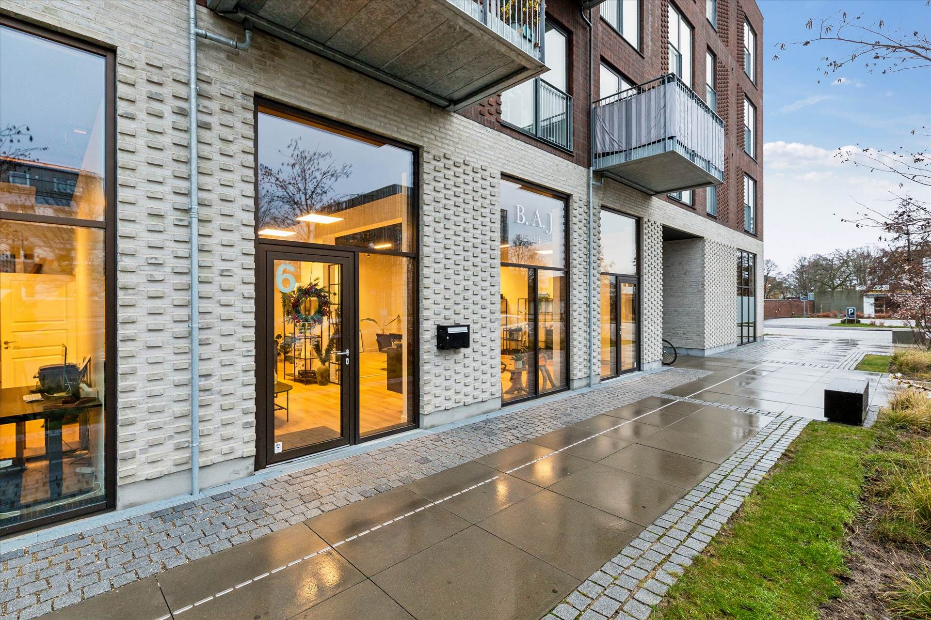 Store glasdøre og -vinduer med nummer 6 og navnet B.A.J i facaden og en butik med indretning og udsmykning