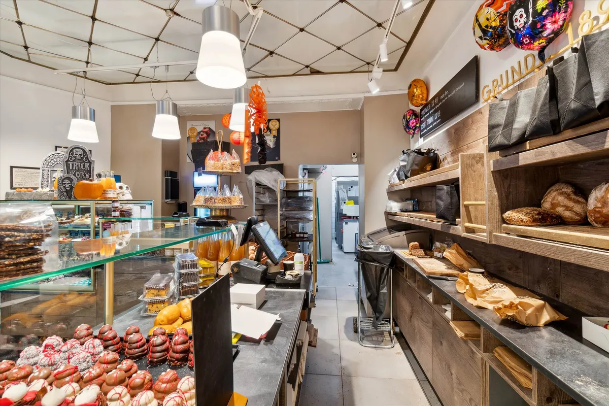 Lyse hyggeligt bageri med sælgende kager og bagværk, dekoreret med pumle og lysekroner