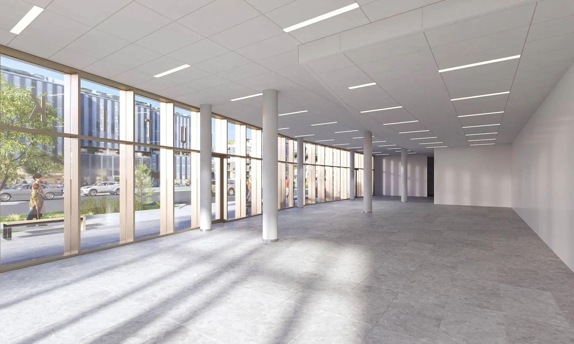 Et tomt, vellyst og moderne kontor med højloft og gul gulv og store vinduer med udsigt til gaden