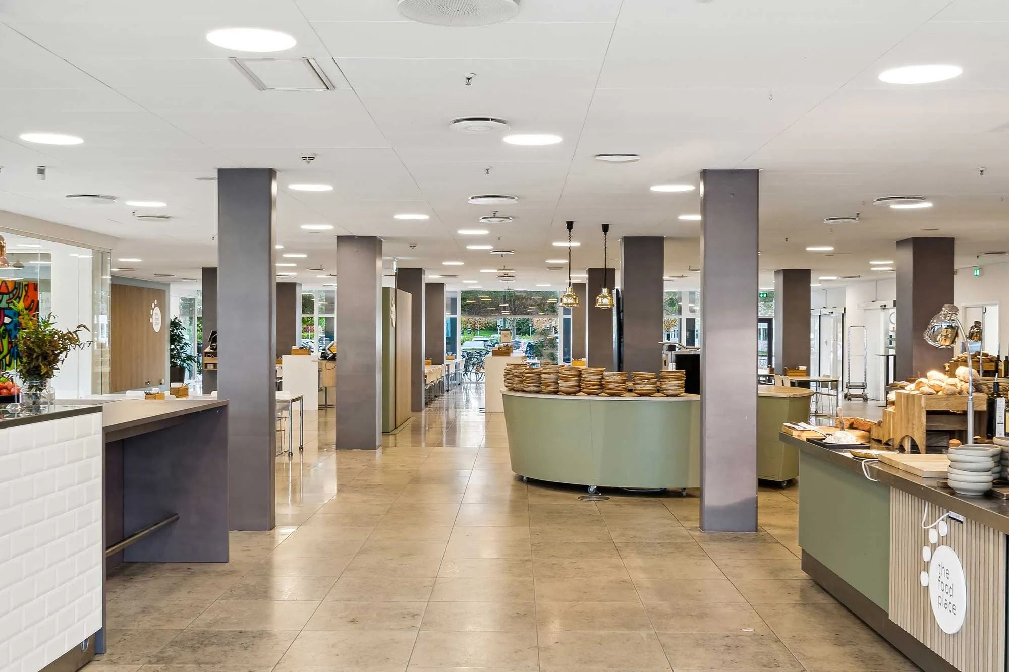 Moderne fællesområde med lyse lofter, højt loft, rundt brødrister, og dekorationer på væggene