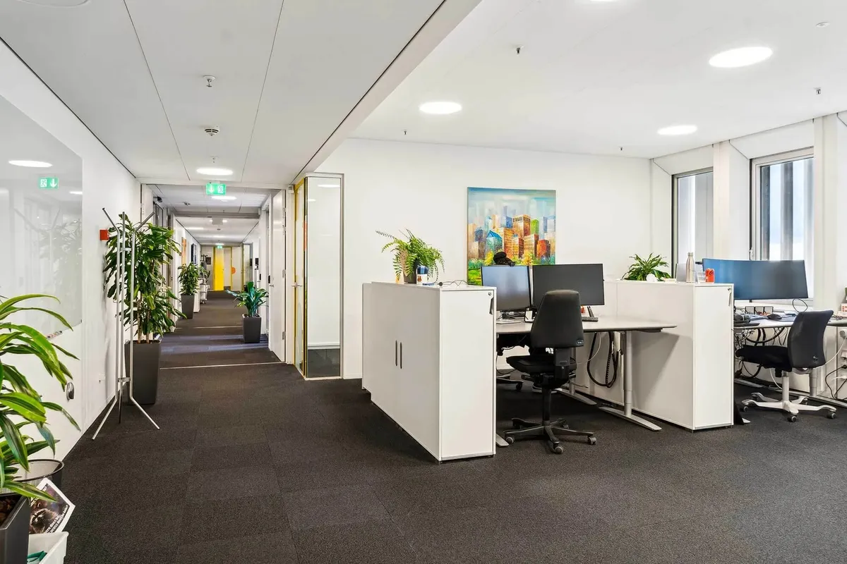 Moderne, rummelige kontorer med højloft og lyse gulve og vægge. Kontorer med højteknologiske computere og møbler, samt