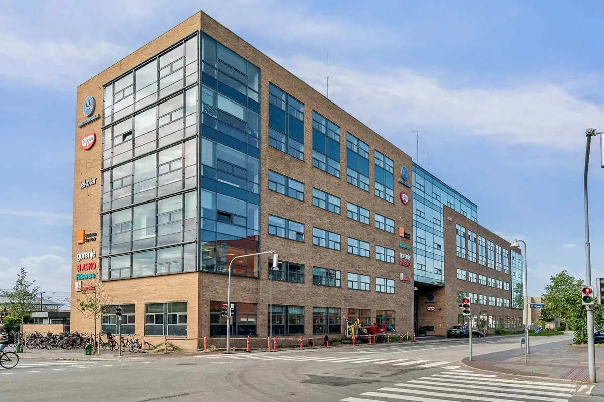 Motorcykelstationen er placeret i et stort bygningskompleks med butikker og kontorer, der ligger ved en vejkryds og en