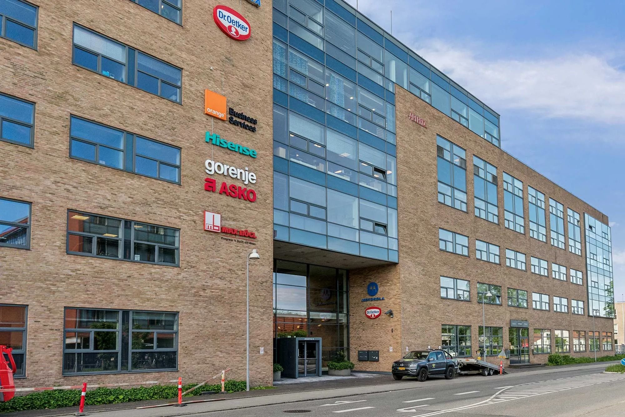 Foto af et kontorhus med Dr. Oetker og Gorenje logoer og en bil parkeret foran