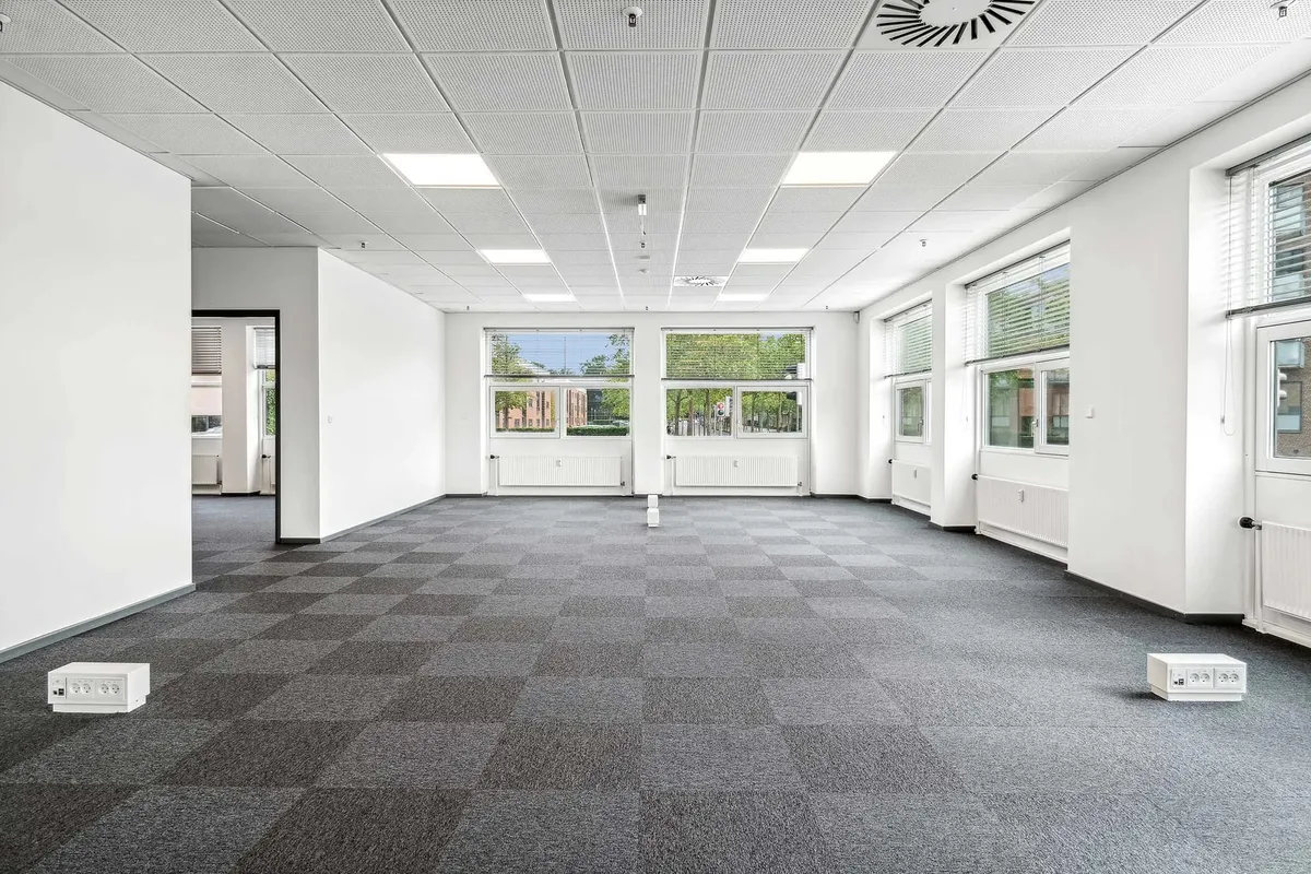 Store og lyse lokaler med hvide vægge og gulve. Værelserne har store vinduer og radiatorer. Der er to vægstik med