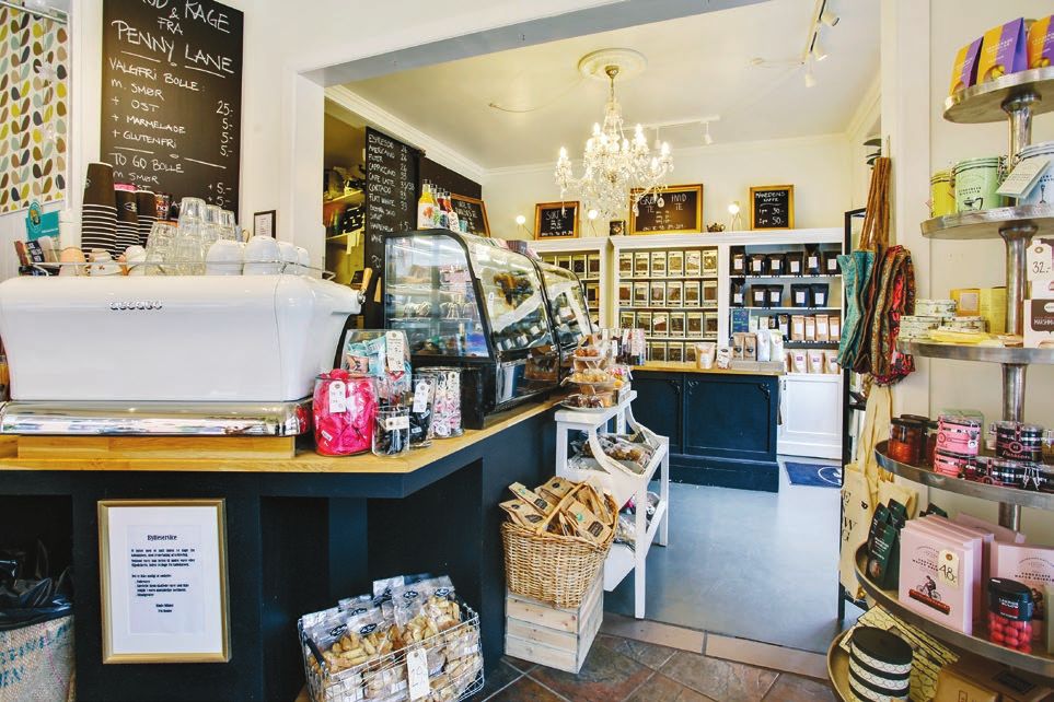 Kaffebaren og delikatesser butik med hyggelig indretning, små skraldespande, lyse gulve og masser af hyggeligt tøj og varer