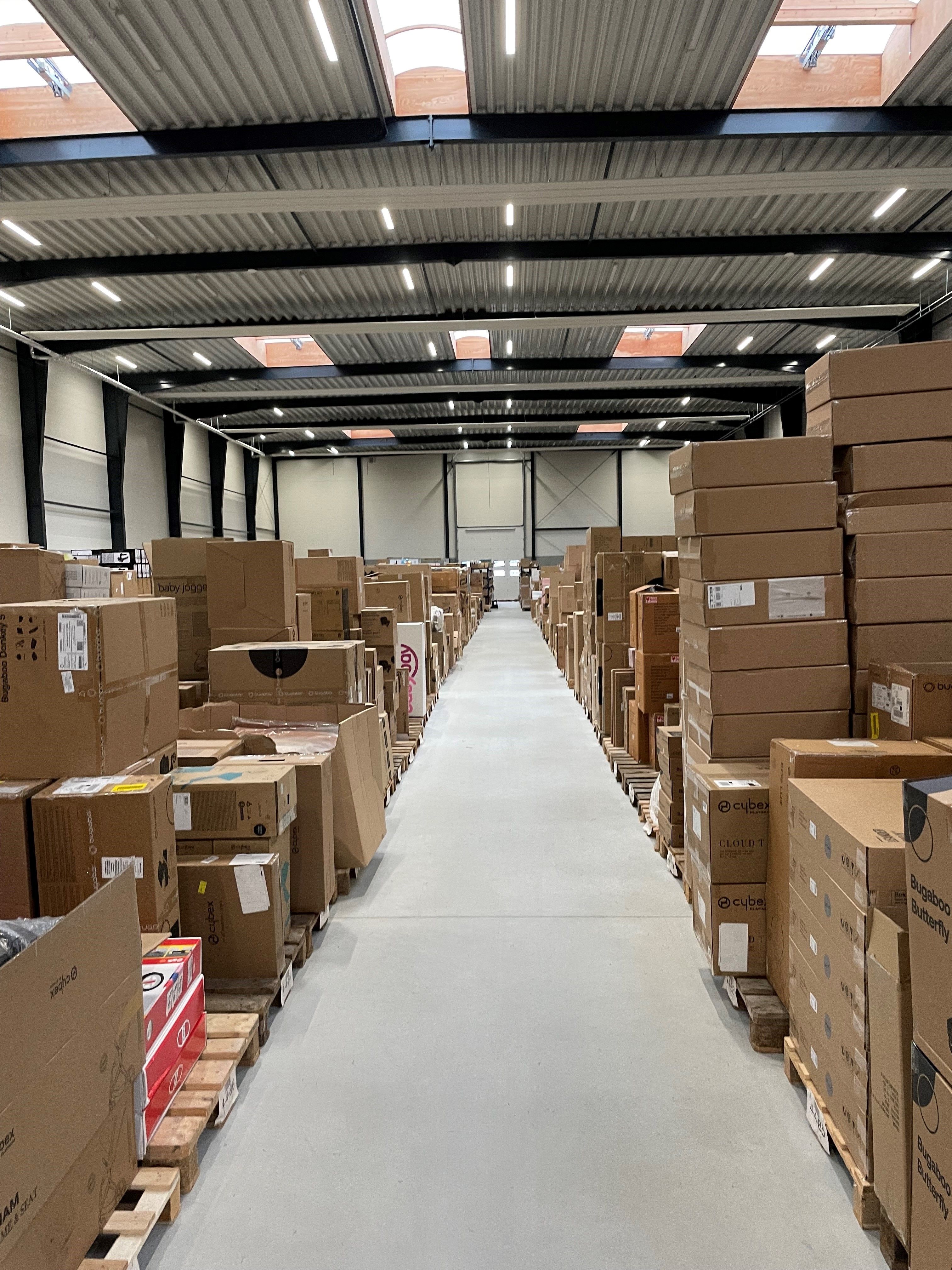 En stor lagerhal fyldt med mange forskelige kasser placeret på paletter med flere gange imellem