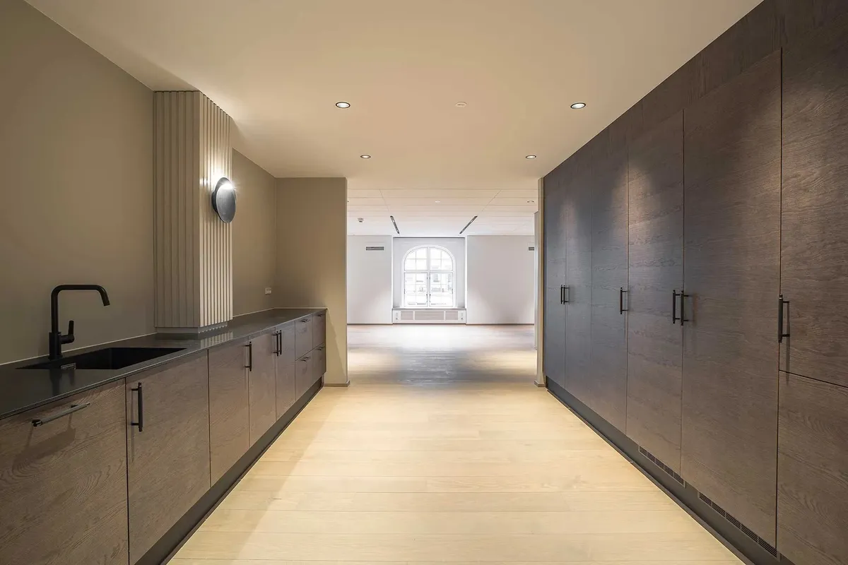 Moderne kontor med træpaneler og hvide vægge, åben gårdhave, minimalistisk design med højloft, lysekroner og lyse gulve