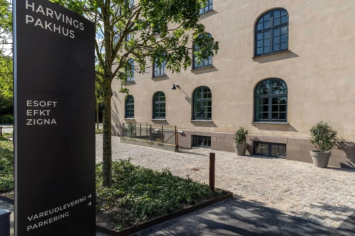 Harvings Pakhus med vareudlevering, parkering og et stort vindue på første sal