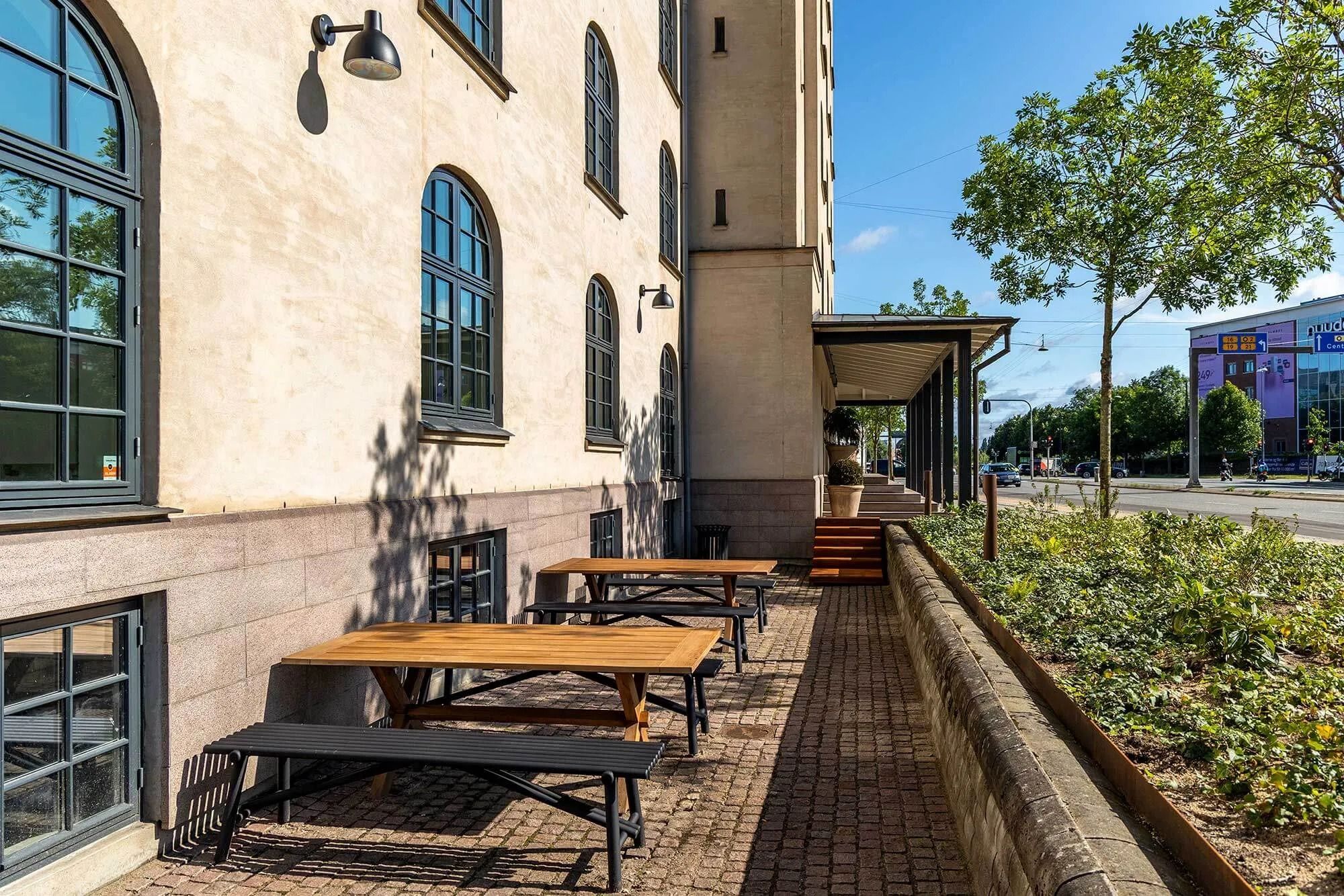 Kantine med udsigt til grønne områder og flere bordsæt og bænke til medarbejdere til afslapning og spisning