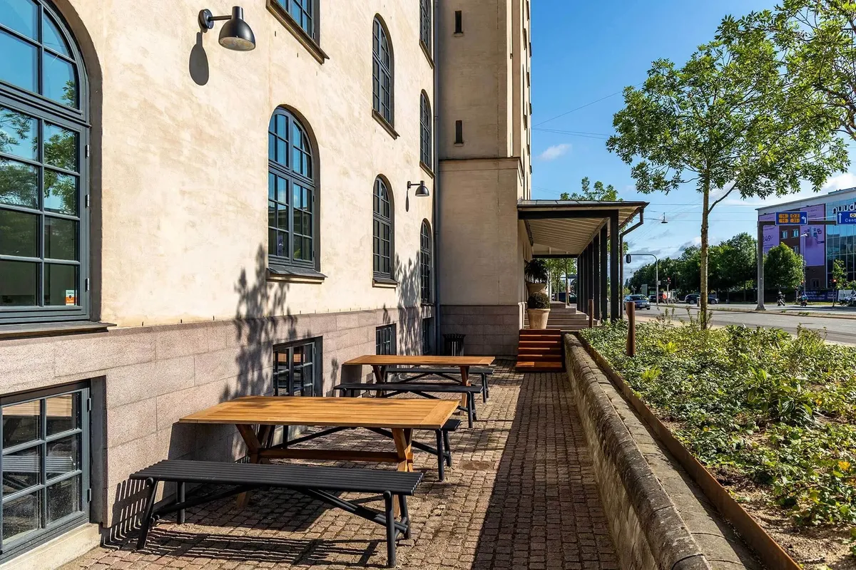 Kantine med udsigt til grønne områder og flere bordsæt og bænke til medarbejdere til afslapning og spisning