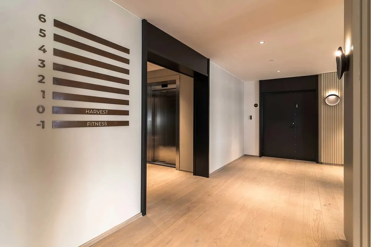 Elegant lobby med lyse loftsbelægning, nummererede etager og to elevatorer, der fører til kontoretage