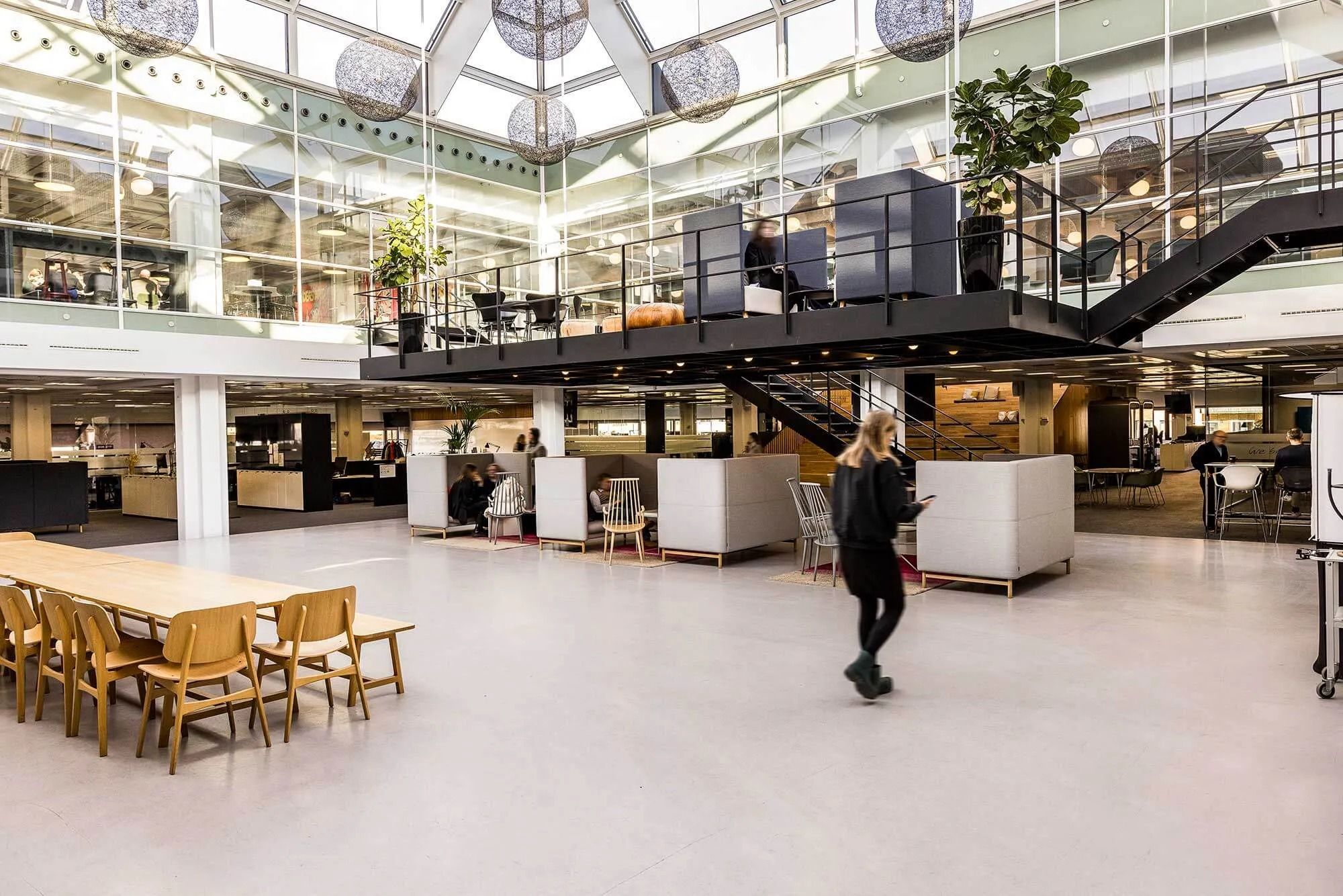 Kontorlokaler med åben indretning, fuld af naturligt lys og lyse områder med skriveborde og stole