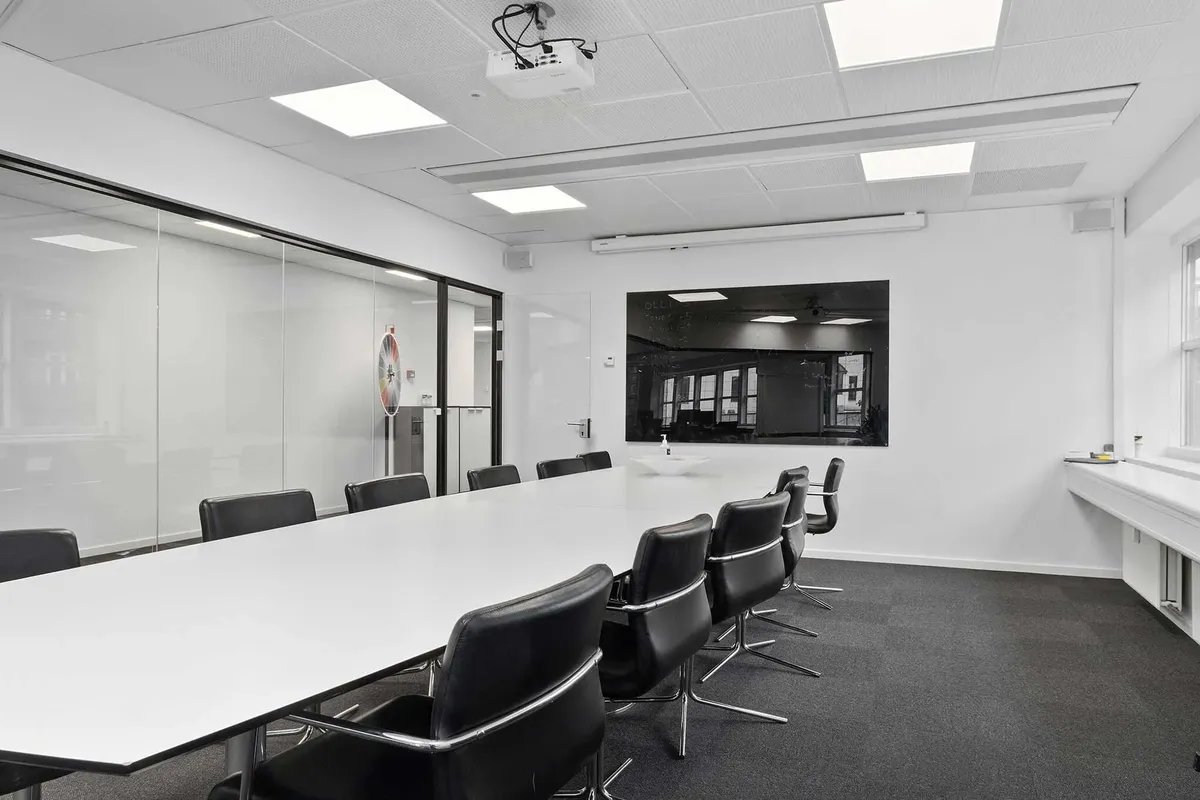 Moderne mødelokale med højt til loftet og store glasruder med udsigt til gaden