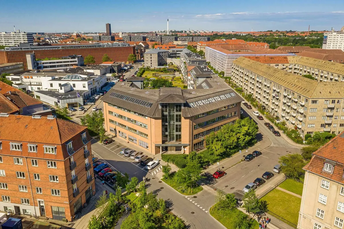 En bygning i et område med mange andre bygninger og grønne arealer