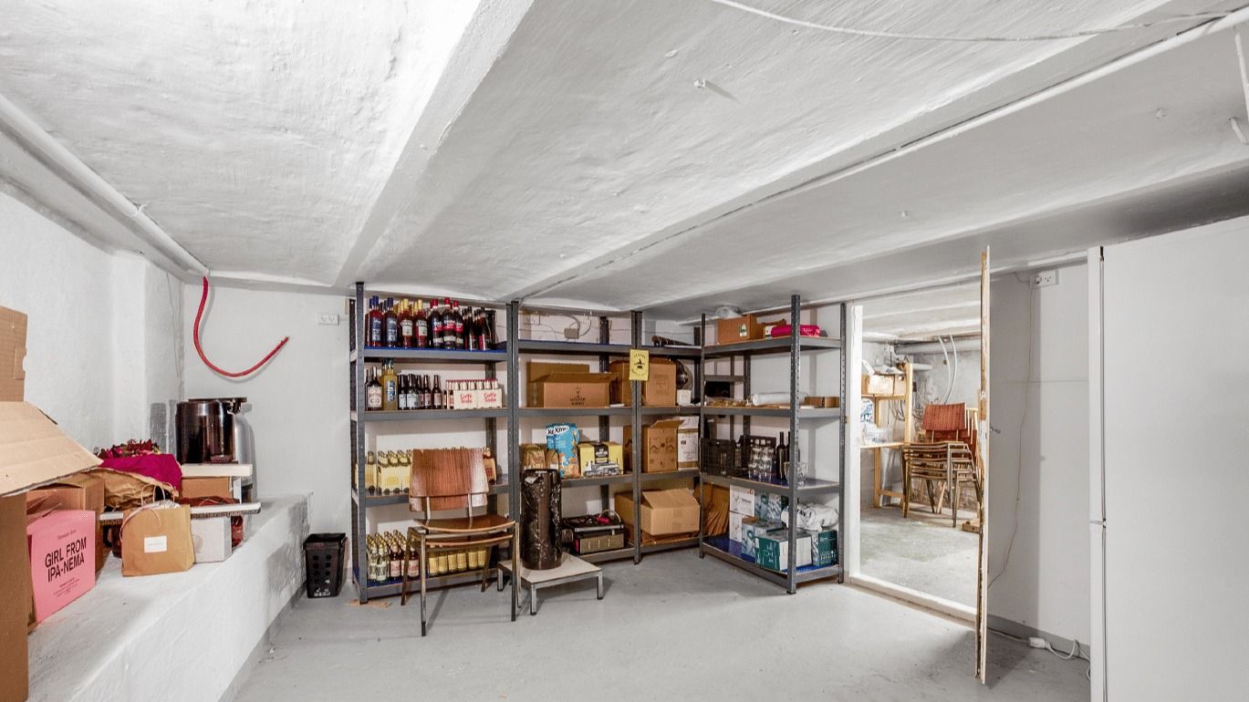 Lagerrum med højloft og mængder af bokse og flasker i rækker og kasserne på højre side af rummet