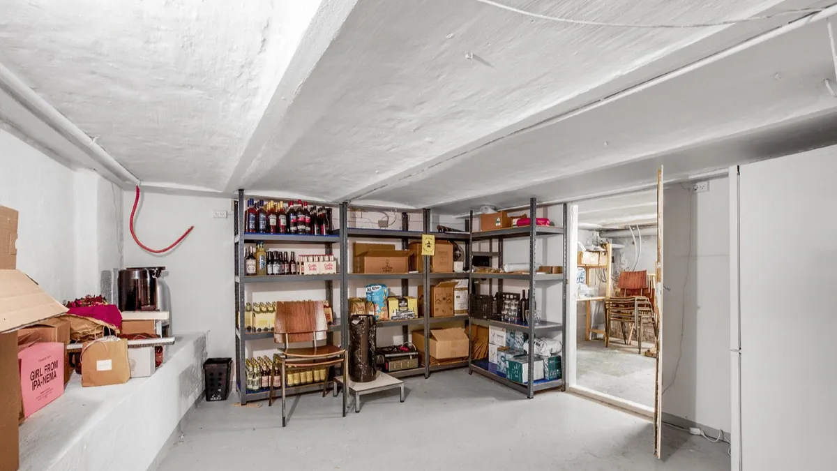 Lagerrum med højloft og mængder af bokse og flasker i rækker og kasserne på højre side af rummet