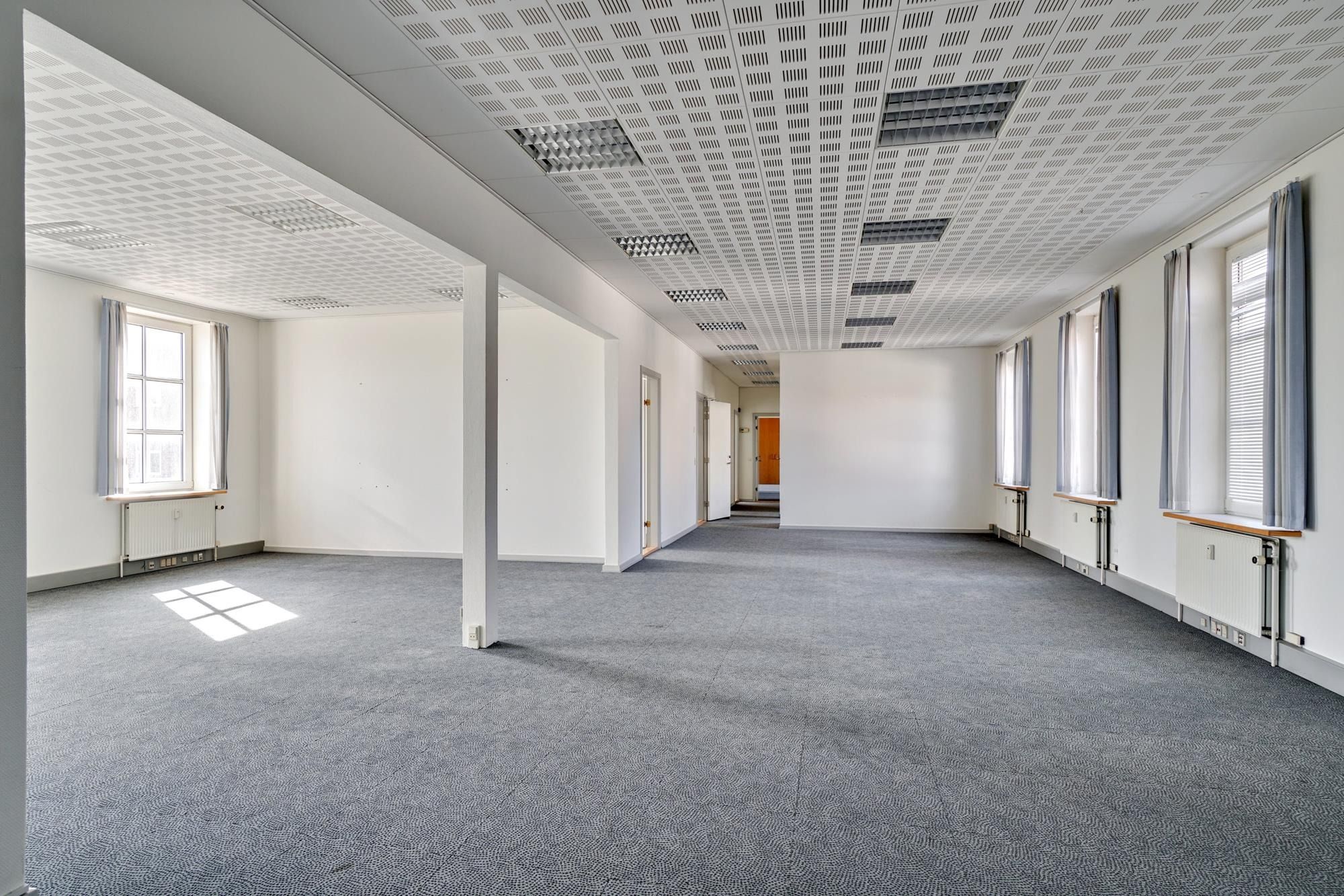 Kortere gange og lokaler med højt til loftet i historisk bygning med lyse og store vinduer