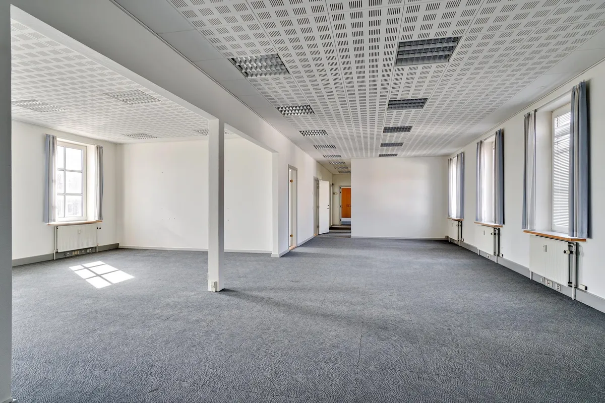 Kortere gange og lokaler med højt til loftet i historisk bygning med lyse og store vinduer
