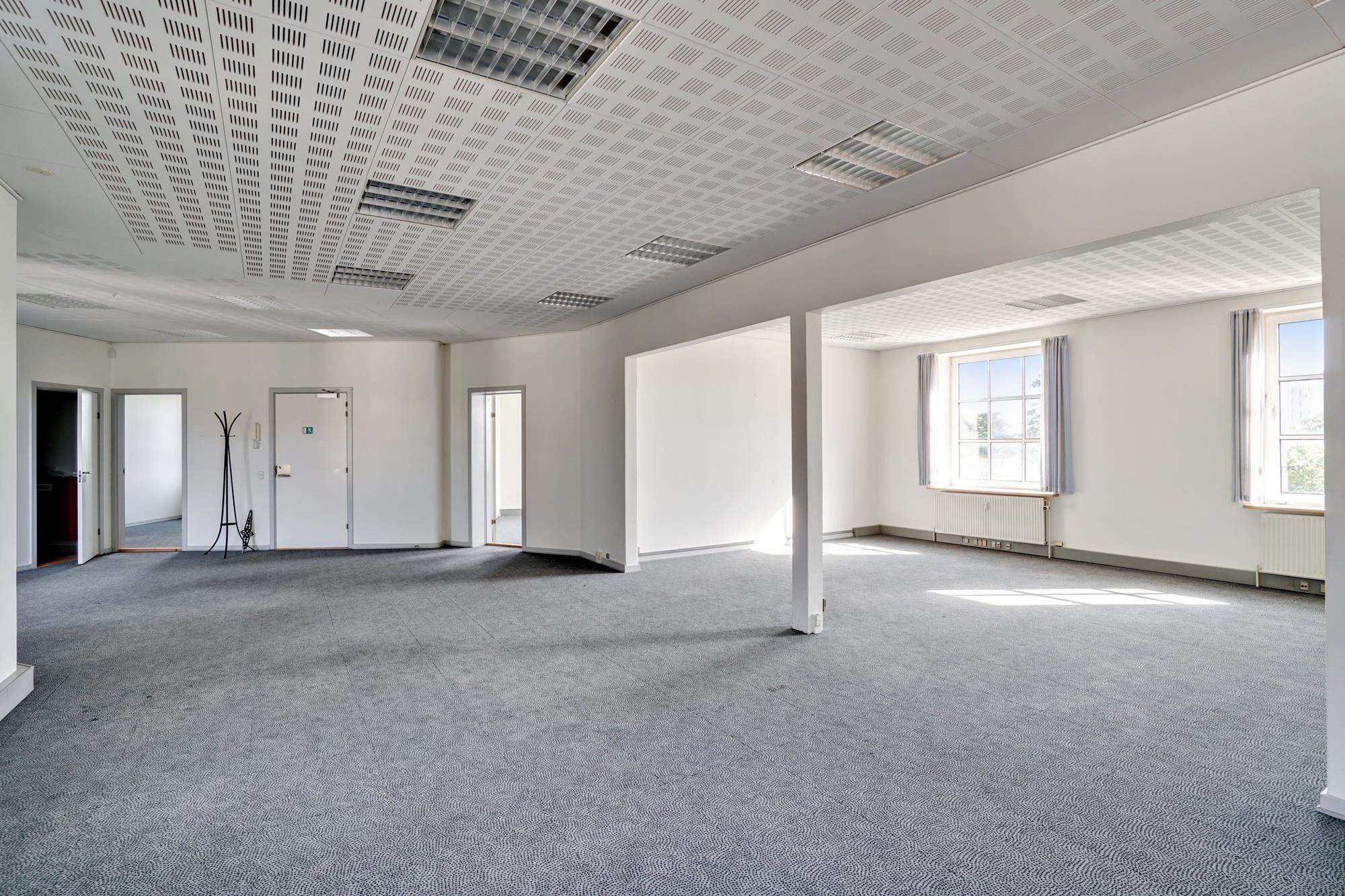 Et stort husrum med lyse vinkler og højt til loftet, møbler og udstyr er ikke synlige