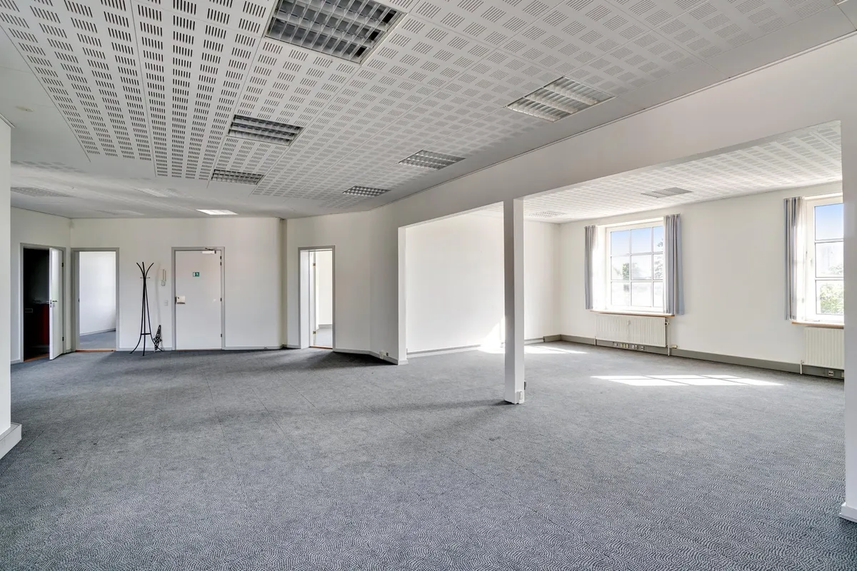 Et stort husrum med lyse vinkler og højt til loftet, møbler og udstyr er ikke synlige