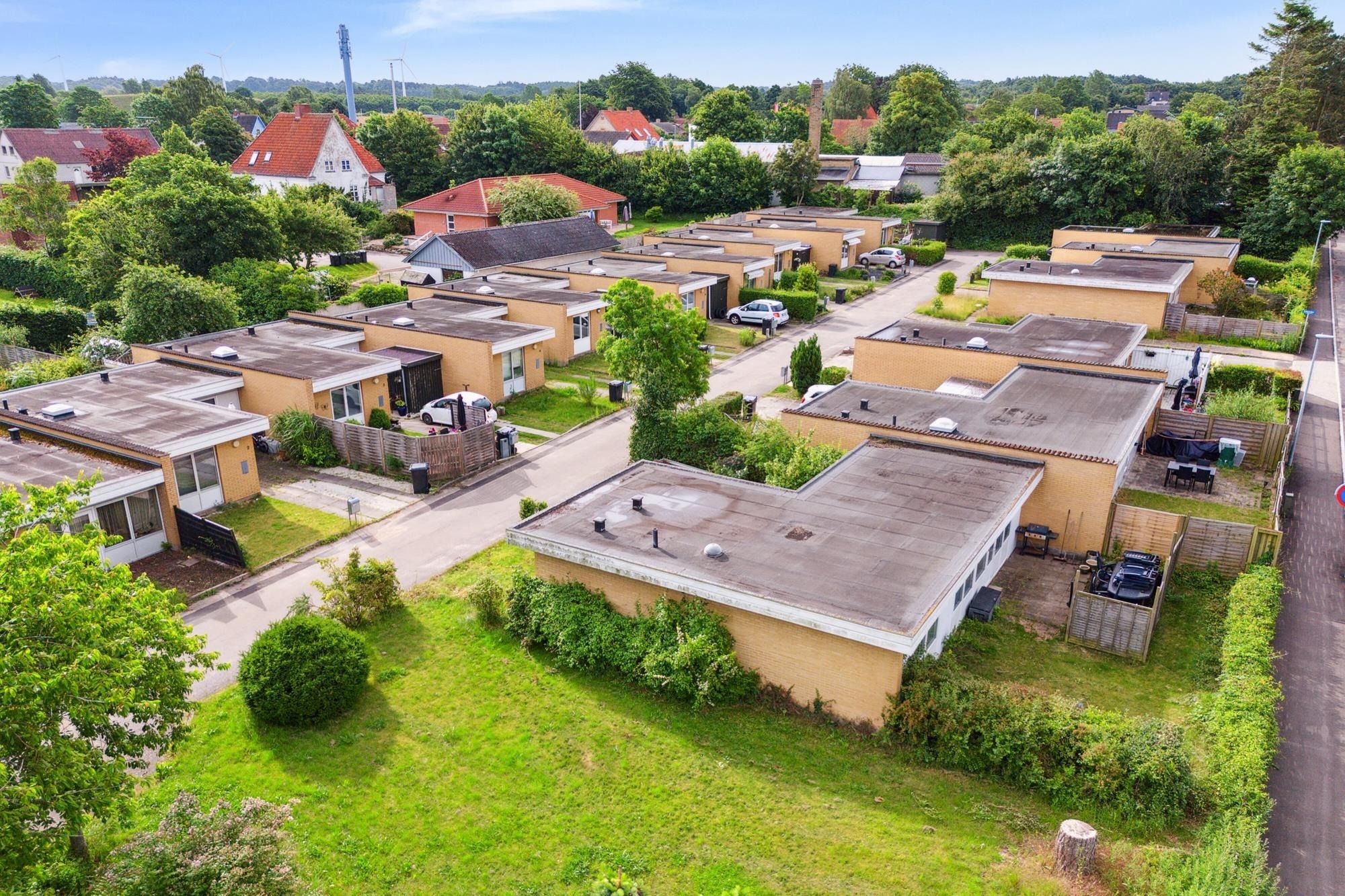 16 moderne rækkehuse med parkeringsplads og have, som ligger i et grønt kvarter med mange træer og buske