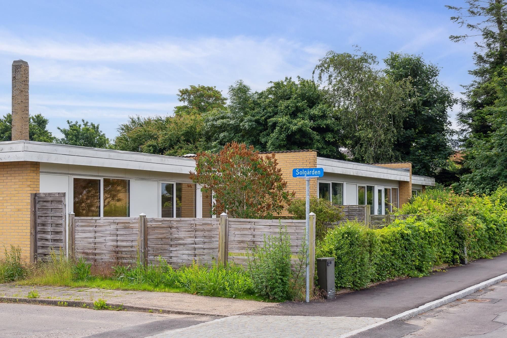 Moderne huse med haver og udsigt til skov. Bygningerne er i røde og hvide mursten og har solcellepaneler. Strømaflæsning på
