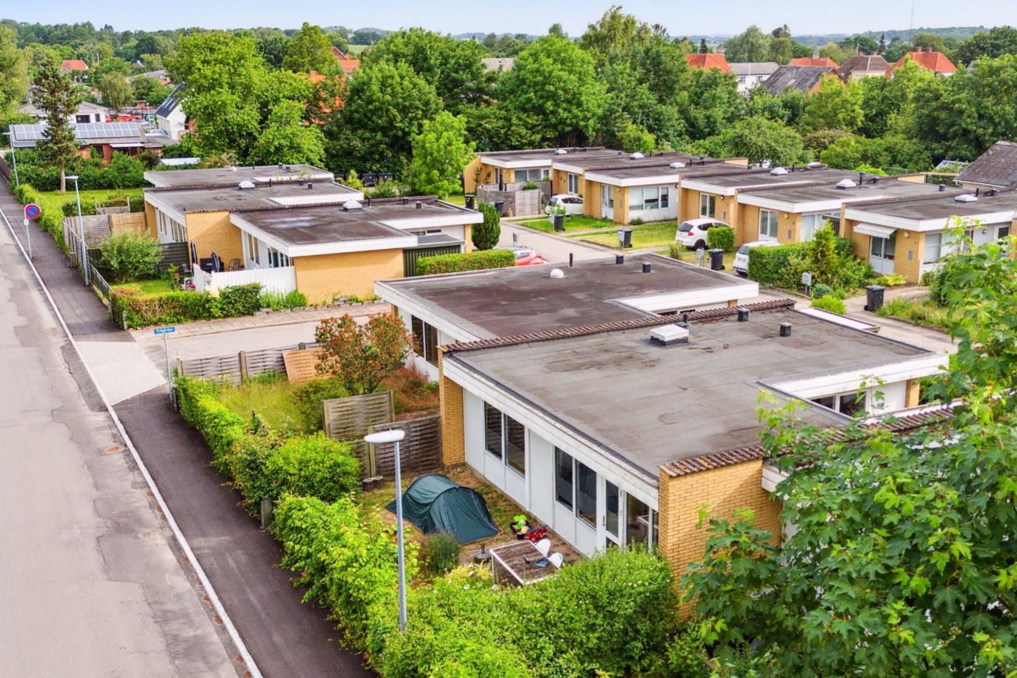 Moderne rækkehuse i en skovområde med hver deres have og udsigt til skov og bygninger