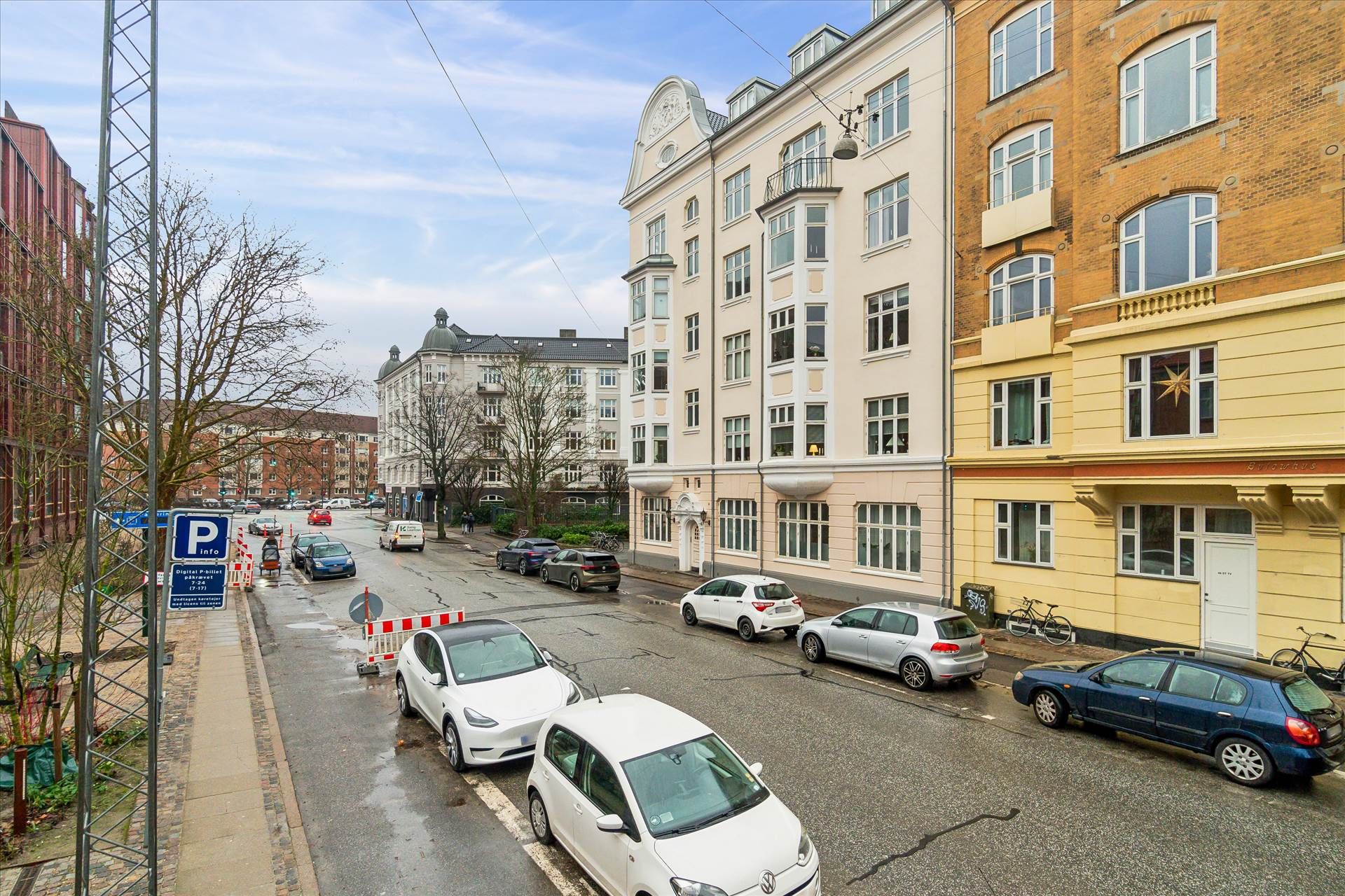 Moderne bygning med udsigt over hovedgaden og parkeret biler på hjørnet af gaden