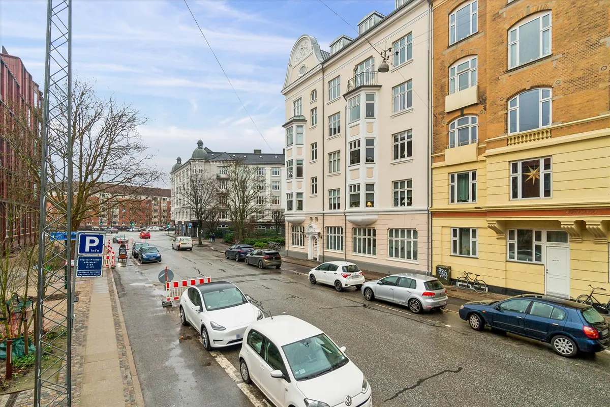 Moderne bygning med udsigt over hovedgaden og parkeret biler på hjørnet af gaden