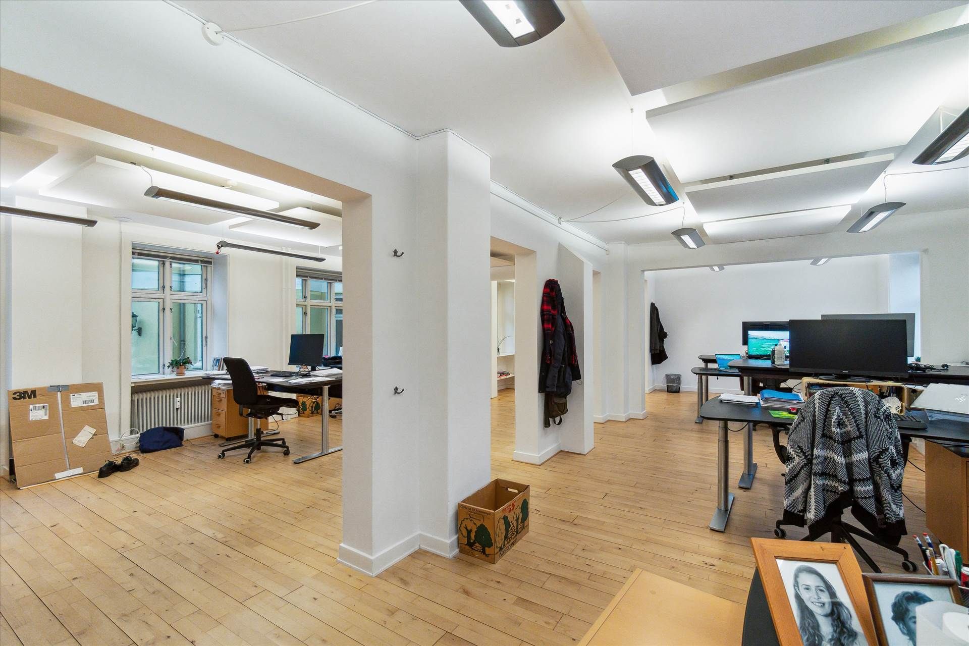 Kontor med højt til loftet, lysegule vægge og møbler, hvor en stol er tom og en køkkenhætte står på bordet