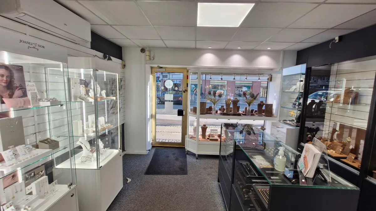 Indvendigt i en elegant smykkeforretning med flere udstille og eksklusive smykker og tilbehør i udstyrede udstiller.