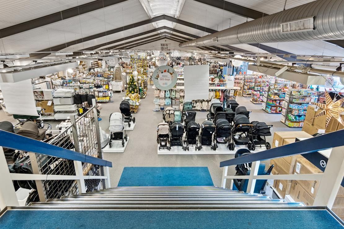 Stort babyudvalg med klapvogn, barneseng og mange andre produkter i en stor butikslokal