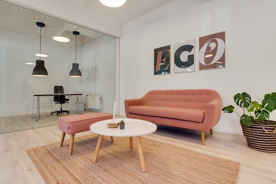 Moderne stue med pink sofa, brun gulvtæppe, hvidt bord, små plantepot og lysekroner