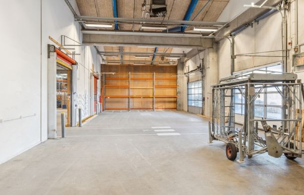 Lager med metalplatform og lastbilrampe i Københavnsområdet, hvor lastbilen er parkeret og lagerrummet er ubenyttet