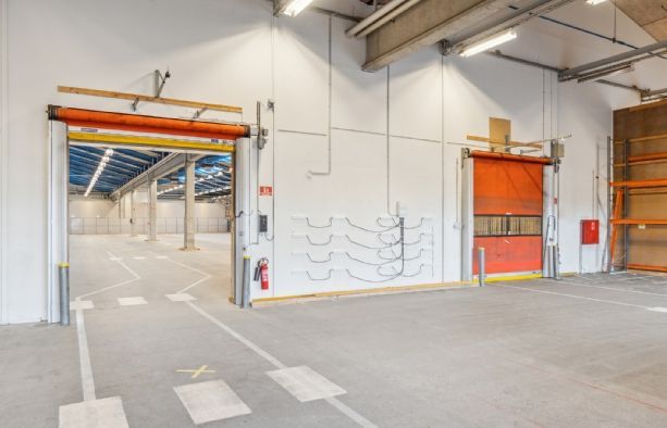 Lager med to store orange porte, en åben og en lukket, samt fire høje gulvmonterede ildslukker