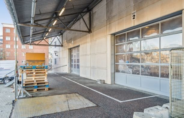 Lager med last mile mulighed, nummer 2, med glasdøre, stående paller og lastbil parkeret ved siden af
