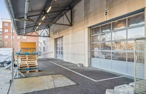 Lager med last mile mulighed, nummer 2, med glasdøre, stående paller og lastbil parkeret ved siden af