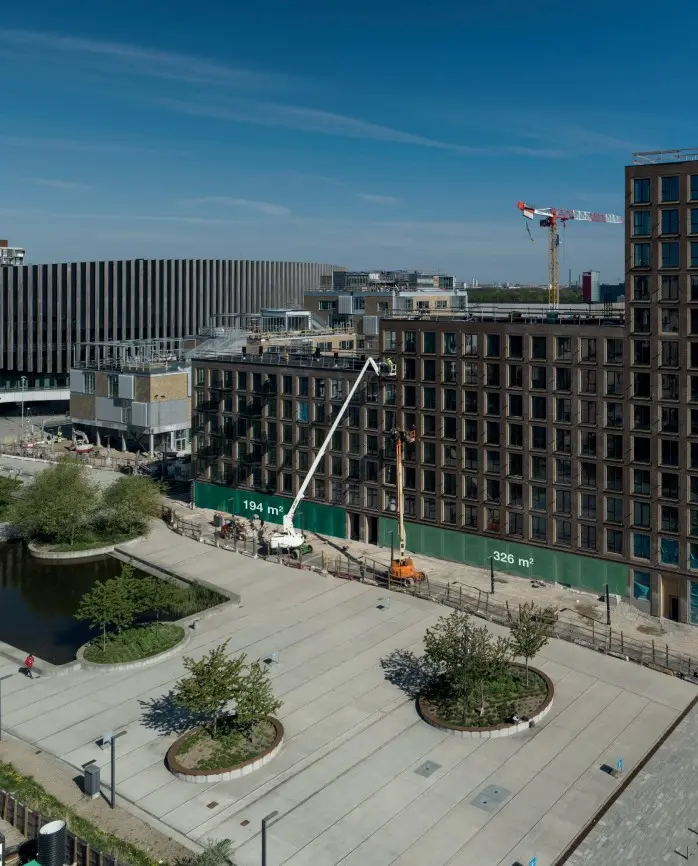Et luftfoto af byggepladsen i Ørestad med flere højhuse og to krane, der ligger på byggepladsen