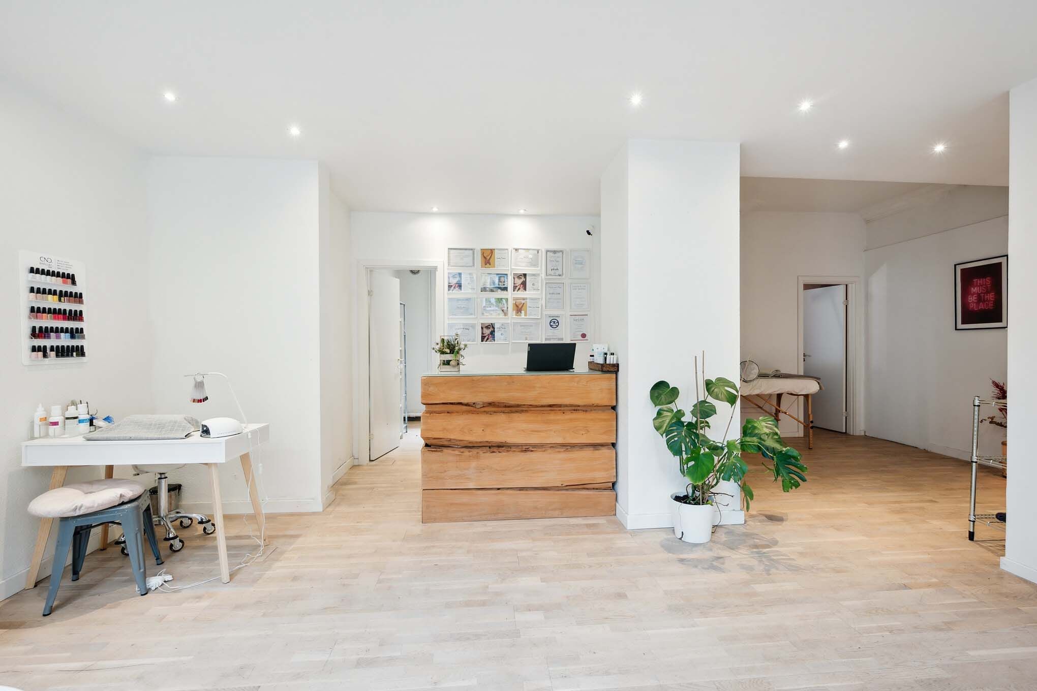 Lejlighed med moderne, minimalistisk indretning og højloftede rum, nyt trægulv og hvidt loft samt stol, skrivebord,