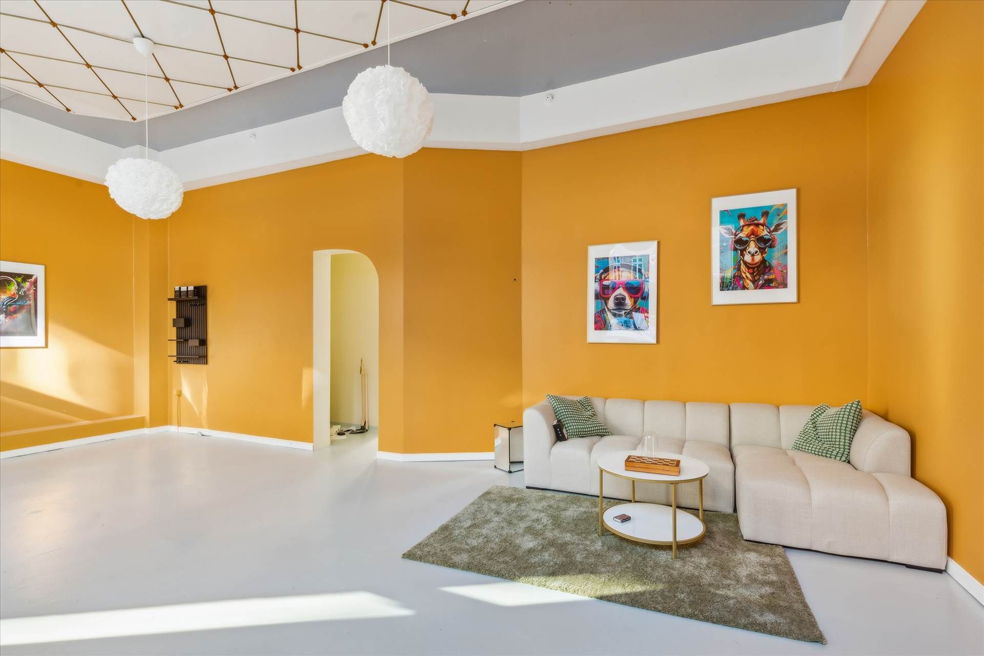 Lys stue med gulvtæppe, lædersofa og højdepunkter i lysegult, hvide vægge og en simpel møbelopsætning