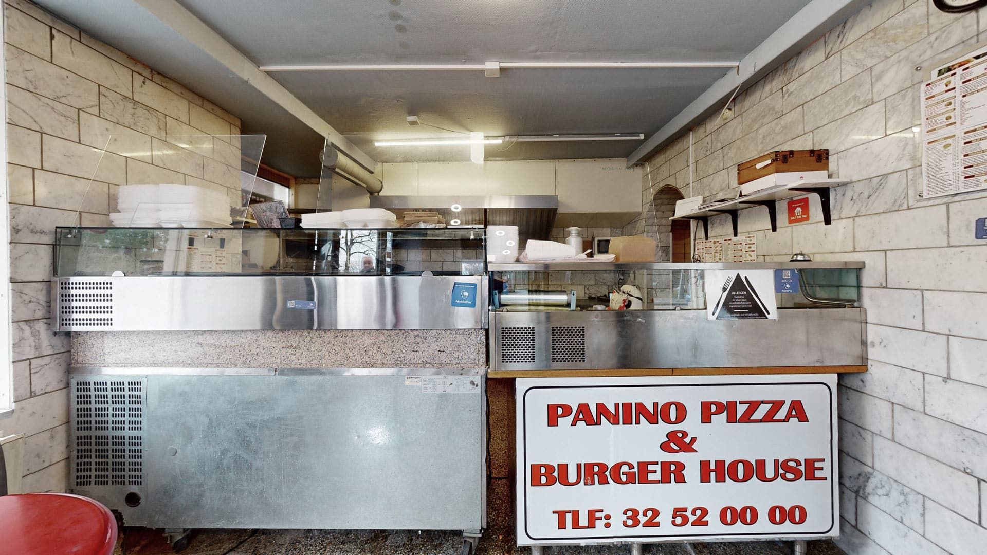 Panino Pizza & Burger House er et sted med udstyr til madlavning og et stort skilt med kontaktoplysninger