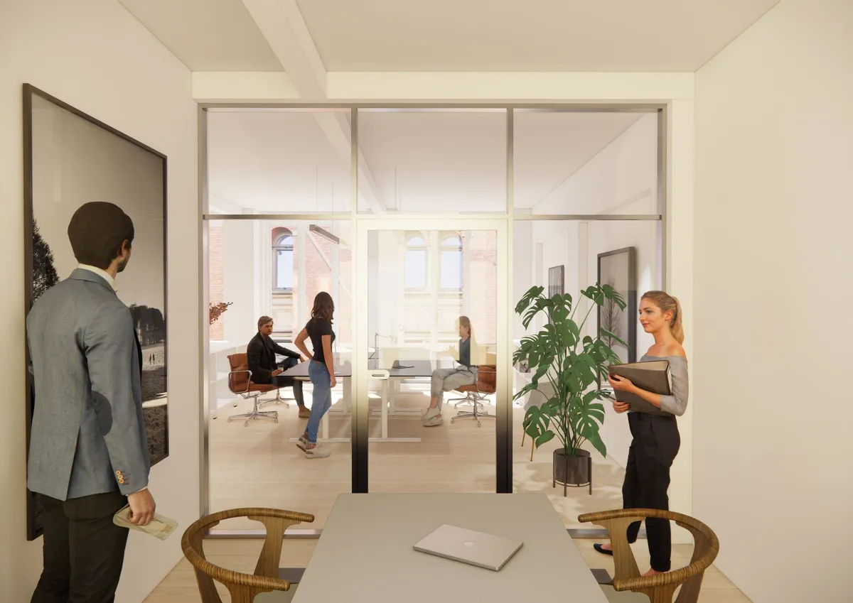 Indenfor et lyst og indbydende kontor er der en kvinde med mappe og en mand i en jakke og bukser