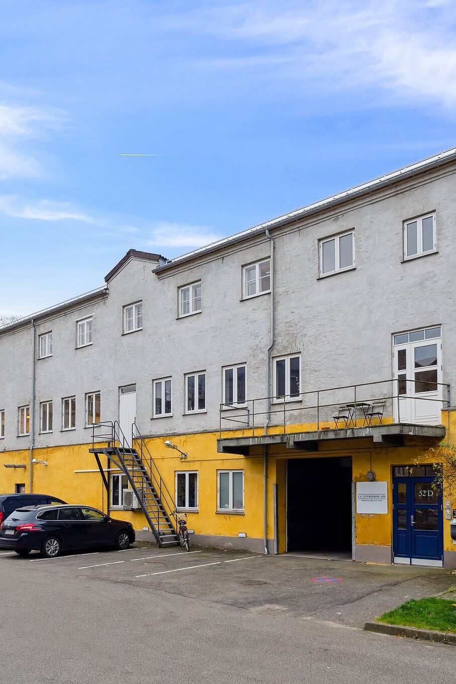 Lejemålet fremtræder i en sjælden stil med gule og grå vægge og mange vinduer, samt en parkeringsplads foran